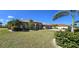 Charming one-story home with lush landscaping, including palm trees and flowering bushes in the front yard at 569 Royal Poinciana, Punta Gorda, FL 33955