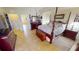 Spacious primary bedroom features a four-poster bed, ensuite bathroom access, and tile floors at 569 Royal Poinciana, Punta Gorda, FL 33955