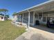 Charming home featuring manicured lawn, gray siding, and shaded carport at 6821 Ocean Ct # Lot 30, North Port, FL 34287