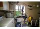 A cluttered laundry area with a washing machine, water heater and shelving at 824 Conreid Ne Dr, Port Charlotte, FL 33952