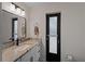 Bathroom features a modern vanity with a black faucet and black-framed door to the exterior at 908 Tropical Nw Cir, Port Charlotte, FL 33948