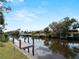 Backyard canal view featuring a private dock and waterfront access at 908 Tropical Nw Cir, Port Charlotte, FL 33948