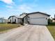 Home exterior showcasing a two-car garage, metal roof, and manicured lawn at 908 Tropical Nw Cir, Port Charlotte, FL 33948