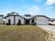 Charming single-story home with a lush lawn, arched windows, and a two-car garage at 908 Tropical Nw Cir, Port Charlotte, FL 33948