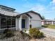 Charming home entrance featuring an arched entryway, a two-car garage, and lush landscaping at 908 Tropical Nw Cir, Port Charlotte, FL 33948