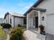 Inviting home entrance with manicured landscaping, stone walkway, and neutral color palette at 908 Tropical Nw Cir, Port Charlotte, FL 33948