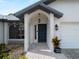 Inviting front entrance featuring a decorative front door, sidelight, and stone paver walkway at 908 Tropical Nw Cir, Port Charlotte, FL 33948