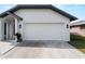 Two-car garage with well-maintained driveway and manicured landscaping at 908 Tropical Nw Cir, Port Charlotte, FL 33948