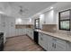 Well-lit kitchen with white cabinets, wood floors, granite counters, and black appliances at 908 Tropical Nw Cir, Port Charlotte, FL 33948