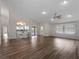 Open living room featuring wood floors, a kitchen bar, and sliding door access to the lanai at 908 Tropical Nw Cir, Port Charlotte, FL 33948