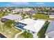 Aerial view of a home with a screened-in pool, lush landscaping, and canal access at 103 Colony Point Dr, Punta Gorda, FL 33950