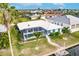 Aerial view of canal-front home with enclosed pool area and well-maintained lawn at 103 Colony Point Dr, Punta Gorda, FL 33950