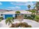 Exterior view of home with lush landscaping, circular driveway, and 2-car garage at 103 Colony Point Dr, Punta Gorda, FL 33950