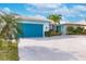 Charming home exterior with a bright blue garage door and well-manicured landscaping at 103 Colony Point Dr, Punta Gorda, FL 33950