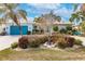 Beautiful home featuring a well-manicured lawn, mature landscaping, and a bright blue garage door at 103 Colony Point Dr, Punta Gorda, FL 33950