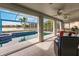 View of pool, lake and luxurious outdoor seating through sliding glass doors at 103 Colony Point Dr, Punta Gorda, FL 33950