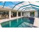 View of the pool and spa from screened in lanai with outdoor seating at 103 Colony Point Dr, Punta Gorda, FL 33950