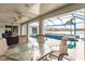 View of the pool and lake from the screened lanai with seating and dining at 103 Colony Point Dr, Punta Gorda, FL 33950