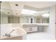 Bright bathroom features a soaking tub, mirrored walls, modern vanity, and white tile floors at 11000 Placida Rd # 1501, Placida, FL 33946