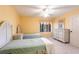 Bright bedroom with twin beds, ceiling fan, yellow walls, and a view of the tropical scenery at 11000 Placida Rd # 1501, Placida, FL 33946