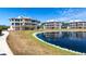 Scenic exterior view of well-maintained condo buildings overlooking a tranquil pond at 11000 Placida Rd # 1501, Placida, FL 33946