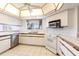 Well-lit kitchen with white cabinetry, tile flooring, and modern appliances at 11000 Placida Rd # 1501, Placida, FL 33946