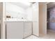 Functional laundry room with washer, dryer, shelving, and access to a half bathroom at 11000 Placida Rd # 1501, Placida, FL 33946