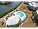 Aerial view of a kidney-shaped community pool with lounge chairs, umbrellas, and landscaping at 11000 Placida Rd # 1501, Placida, FL 33946