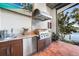 Outdoor kitchen features a stainless grill and mini-fridge, perfect for entertaining at 1111 San Mateo Dr, Punta Gorda, FL 33950