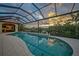 Relaxing screened pool area featuring a covered outdoor kitchen and views of the surrounding waterfront landscape at 1111 San Mateo Dr, Punta Gorda, FL 33950