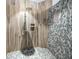 Custom shower with unique tiling, modern shower head fixture and wood-look surround at 1111 San Mateo Dr, Punta Gorda, FL 33950