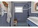Stylish bathroom with blue patterned tile, a modern shower head, and a wood and white seat at 131 Buckeye Nw Ave, Port Charlotte, FL 33952