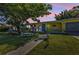 Charming single-story home featuring a brightly painted exterior, blue shutters, an expansive lawn, and whimsical yard art at 131 Buckeye Nw Ave, Port Charlotte, FL 33952