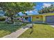 Charming, brightly painted single-story home with a well-manicured lawn and lovely landscaping, exuding curb appeal at 131 Buckeye Nw Ave, Port Charlotte, FL 33952