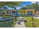 Charming home with an eclectic front yard, inviting curb appeal and vibrant colors at 131 Buckeye Nw Ave, Port Charlotte, FL 33952