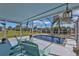 Inviting screened-in pool area featuring seating, and lush landscaping at 131 Buckeye Nw Ave, Port Charlotte, FL 33952