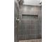 Modern shower with gray tile, pebble floor, and a recessed shelf at 131 Buckeye Nw Ave, Port Charlotte, FL 33952