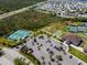 Aerial view of community featuring tennis, pickleball and shuffleboard courts, parking, and grassy areas at 13352 Creekside Ln, Port Charlotte, FL 33953