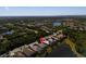 Aerial view of a lovely waterside home in a beautiful neighborhood surrounded by mature trees and green landscaping at 13352 Creekside Ln, Port Charlotte, FL 33953
