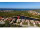 Scenic aerial view of waterfront homes, featuring lush landscaping, a tranquil lake and beautiful bay views at 13352 Creekside Ln, Port Charlotte, FL 33953