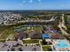 Community aerial view featuring a pool, tennis courts, clubhouse, and lush landscaping at 13352 Creekside Ln, Port Charlotte, FL 33953