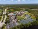 High-angle aerial showcasing a community's pool, tennis courts, clubhouse, parking facilities, and green surroundings at 13352 Creekside Ln, Port Charlotte, FL 33953