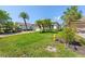 Lush front yard with vibrant hibiscus, mature palms, and a well-maintained lawn at 13352 Creekside Ln, Port Charlotte, FL 33953