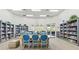 Community library featuring walls of bookshelves, natural light, and a table with blue chairs for gathering at 13352 Creekside Ln, Port Charlotte, FL 33953
