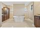 Bright bathroom featuring a soaking tub, dual shower, neutral tile, and beautiful cabinets at 1341 Pine Siskin Dr, Punta Gorda, FL 33950
