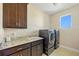 This laundry room features a utility sink, washer, dryer, and custom cabinets at 1341 Pine Siskin Dr, Punta Gorda, FL 33950