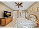 Comfortable bedroom with a ceiling fan, tile floors, and a large TV for relaxing evenings at 1341 Pine Siskin Dr, Punta Gorda, FL 33950