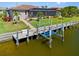 Rear view of a waterfront property featuring a boat lift, screened lanai, and manicured lawn at 1341 Pine Siskin Dr, Punta Gorda, FL 33950