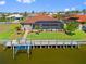 View of canal-front house with screened-in pool, boat lift, and lush landscaping at 1341 Pine Siskin Dr, Punta Gorda, FL 33950