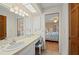 Bright bathroom featuring a vanity, large mirror, and adjacent bedroom view at 1408 San Cristobal Ave # 4, Punta Gorda, FL 33983
